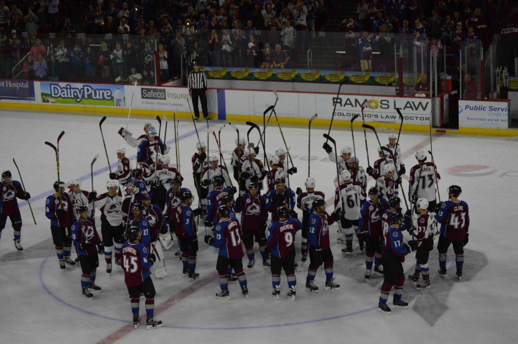 The White and Burgundy meet at center ice. Photo by Julie Gunderson