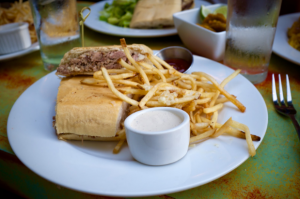 The reviewer’s Pan con Lechon sandwich and mojo fries. Justin Cygan | Clarion