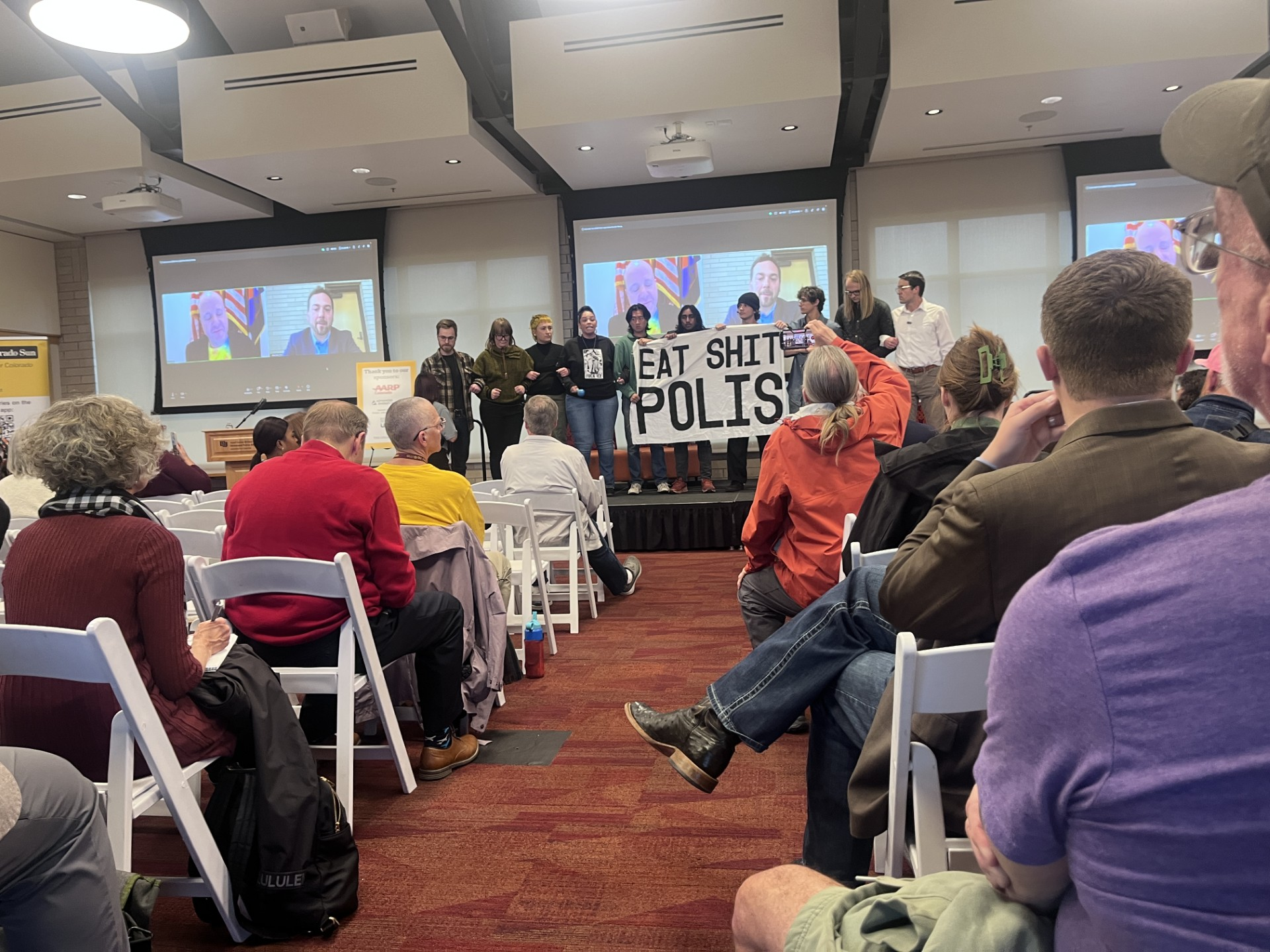 Polis protesters disrupt an event he didn't bother to attend